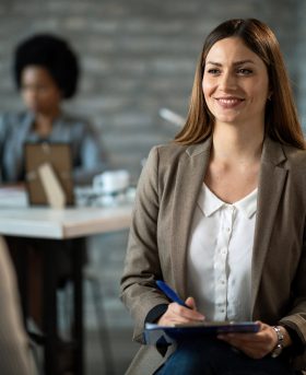 Smiling insurance agent talking with young couple on a meeting in her office.