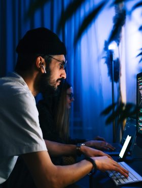 Mobile developers team writes program code on a computer, programmers work in home office.