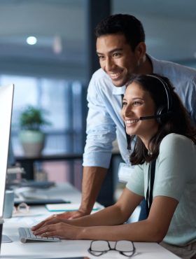 Shot of a young man and woman using a computer while working in a call centre.